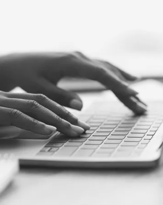 Hands typing on laptop keyboard