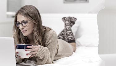 Woman on computer in bed