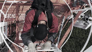 Technician climbing telecom tower